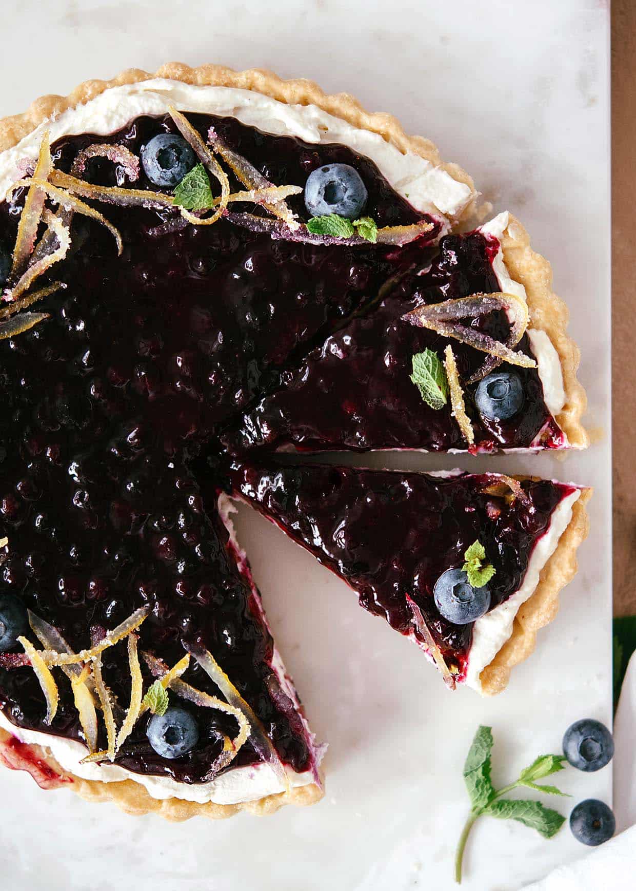 whole blueberry cream pie with two slices cut out