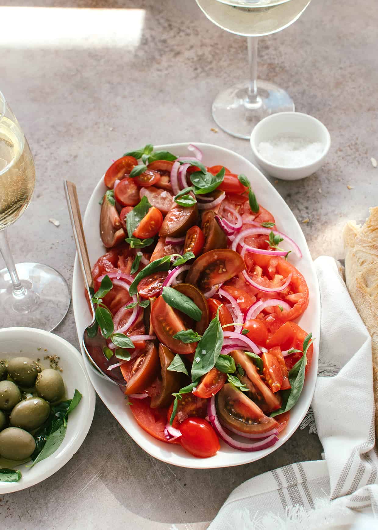 sliced tomatoes with basil and onion served on a plate