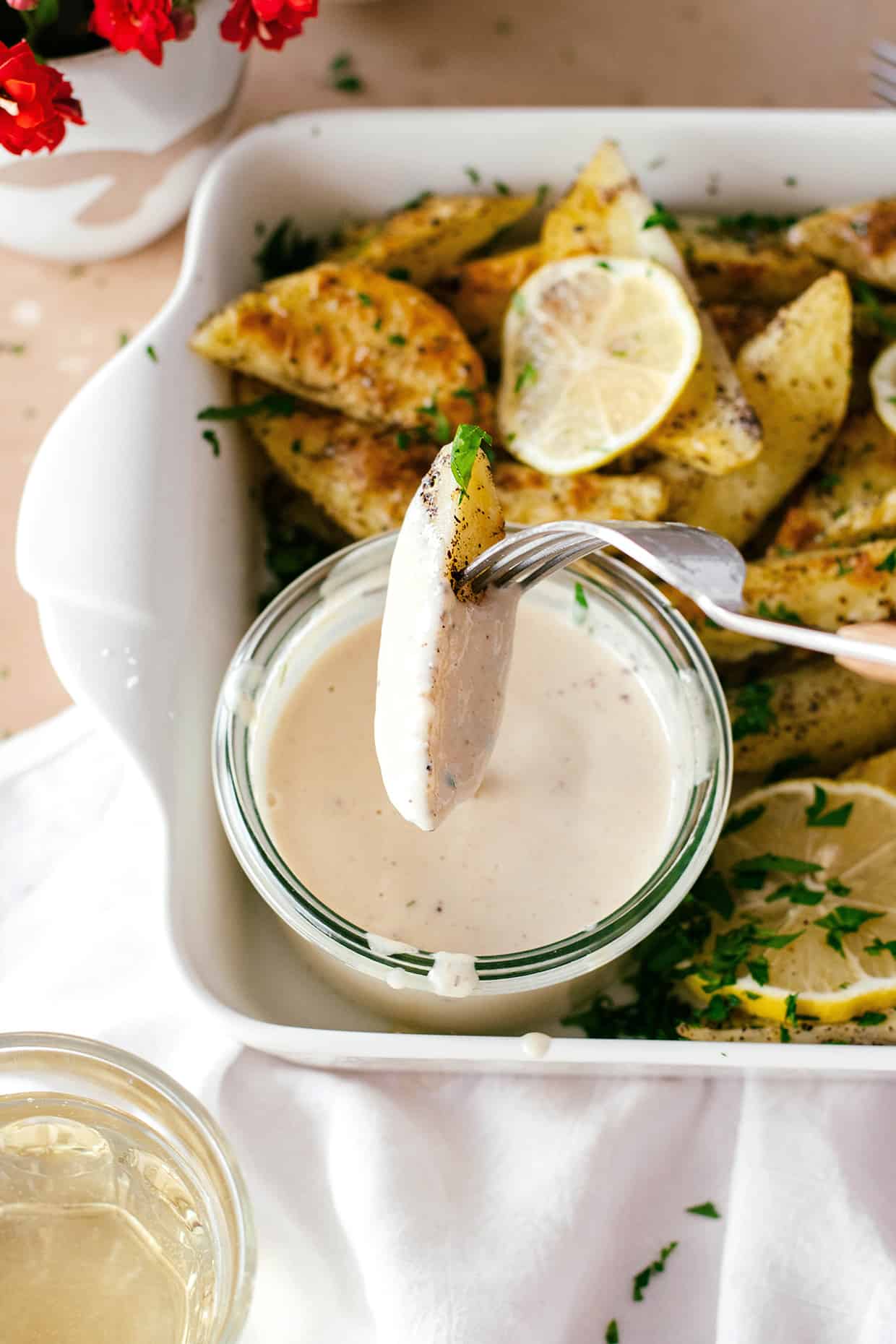 roasted potato wedge dipped into tahini sauce