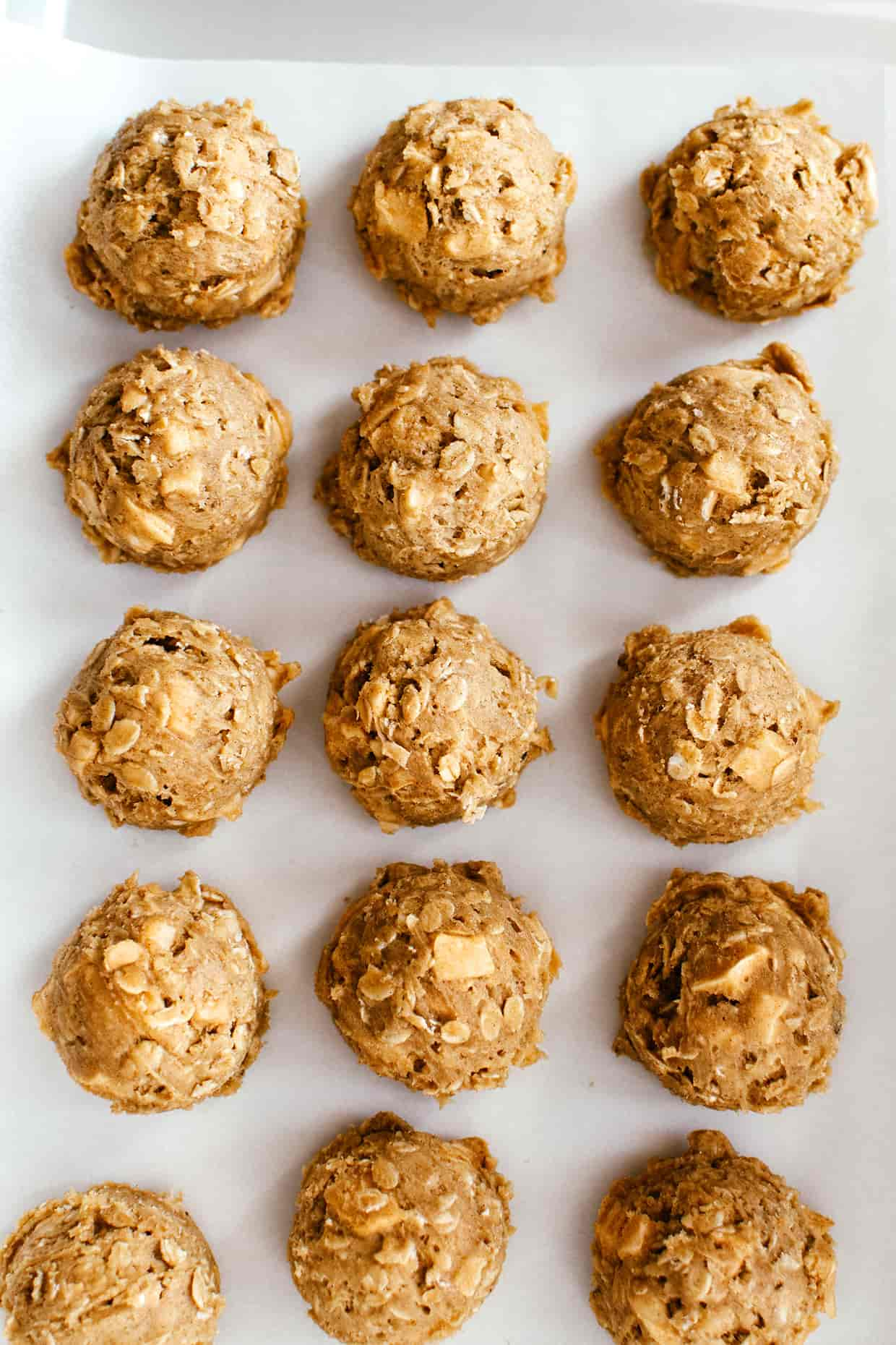 raw scooped cookie dough on a baking sheet