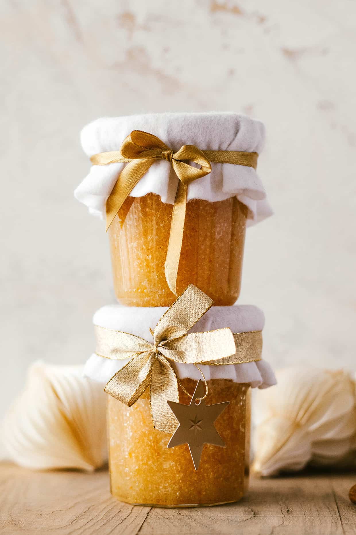 glass jars with Cinnamon orange sugar scrub stacked on top of each other