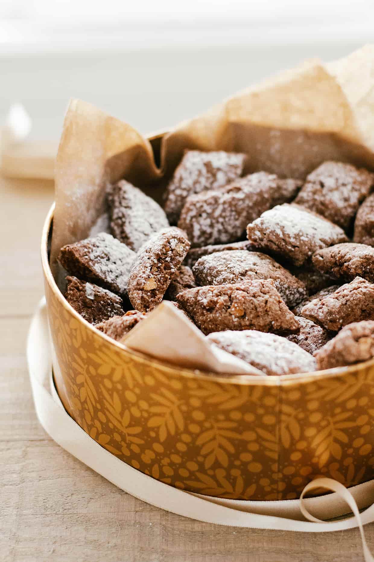 brown cookies dusted with sugar in a cookie tin