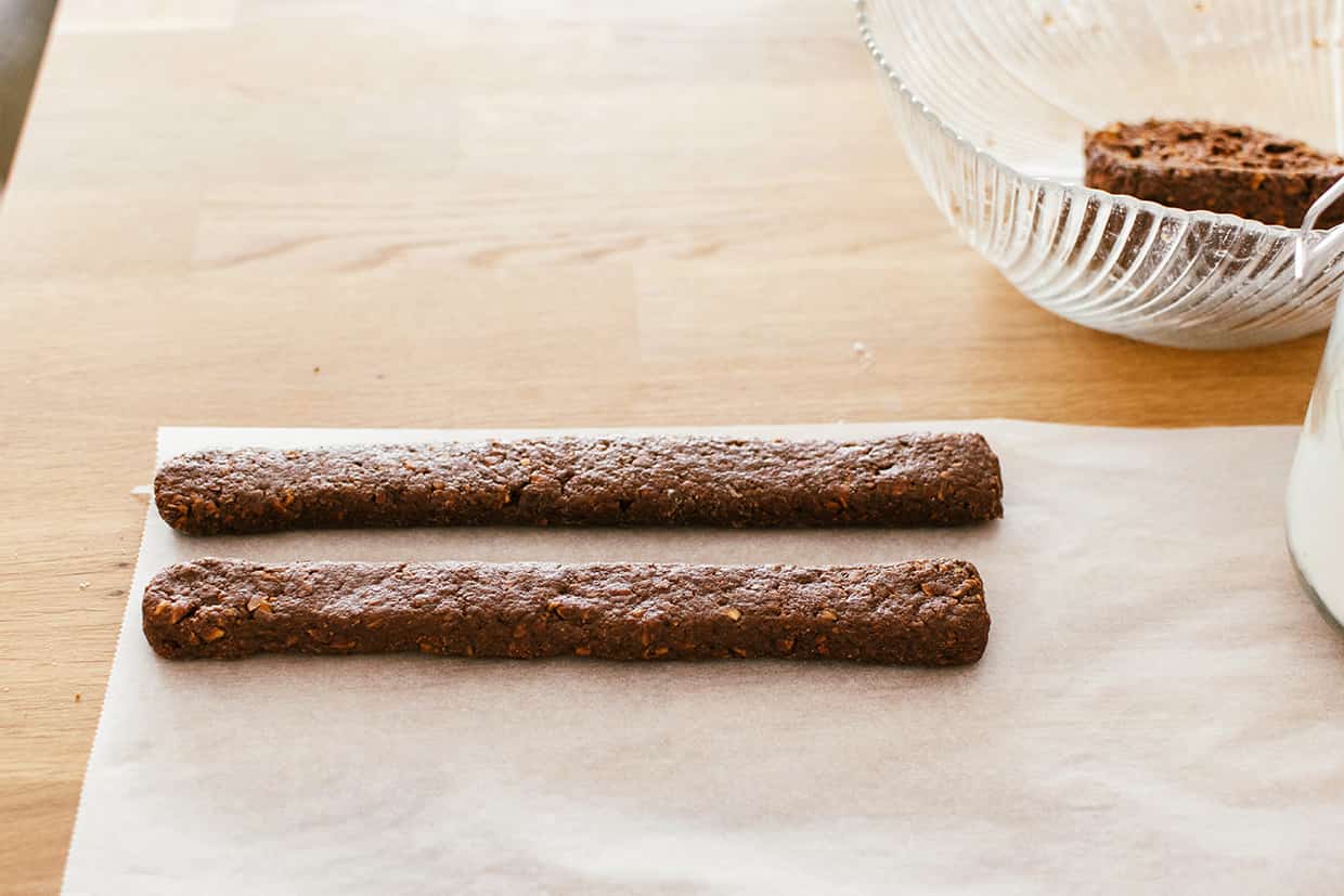 two logs of cocoa cookie dough on parchment paper