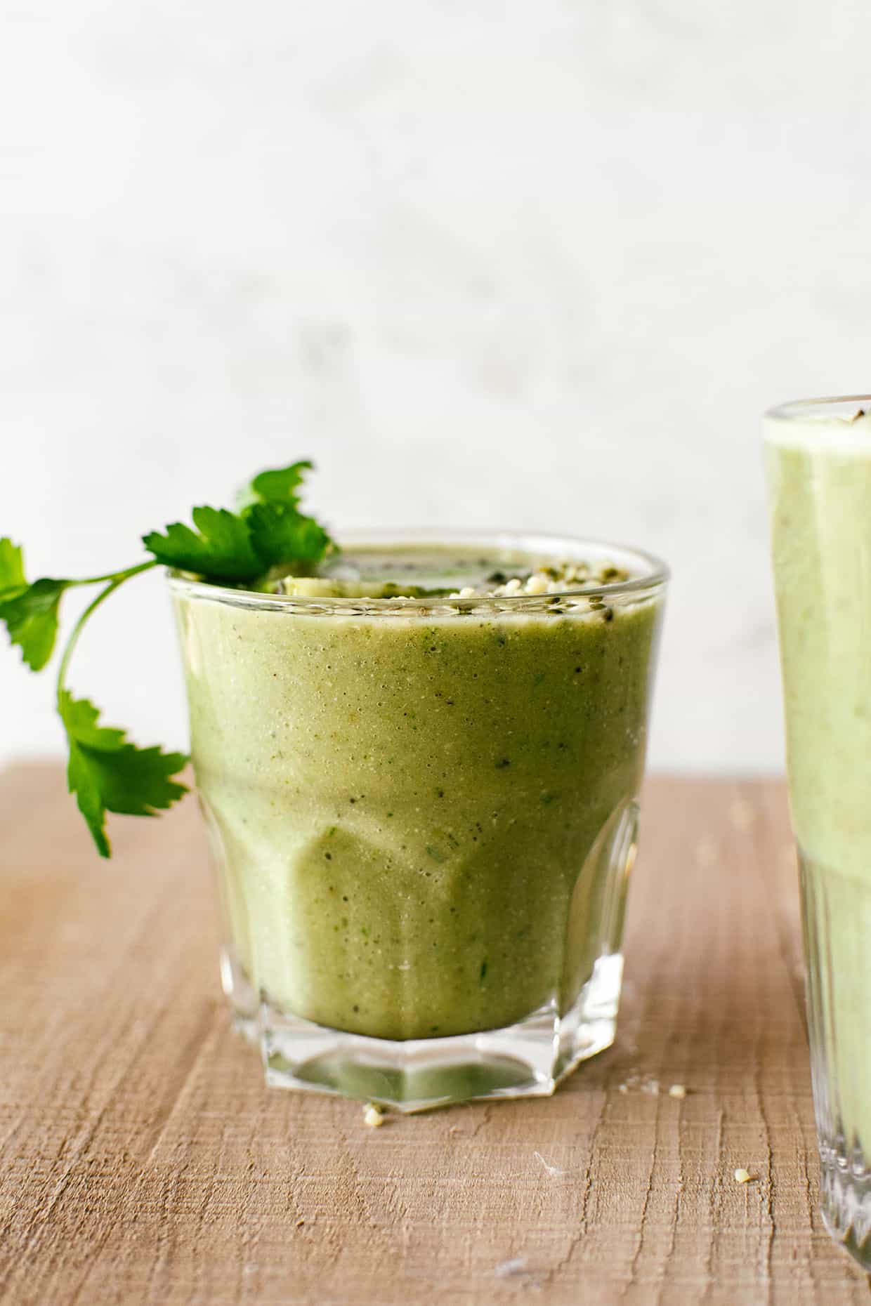 green smoothie in a glass with parsley on top