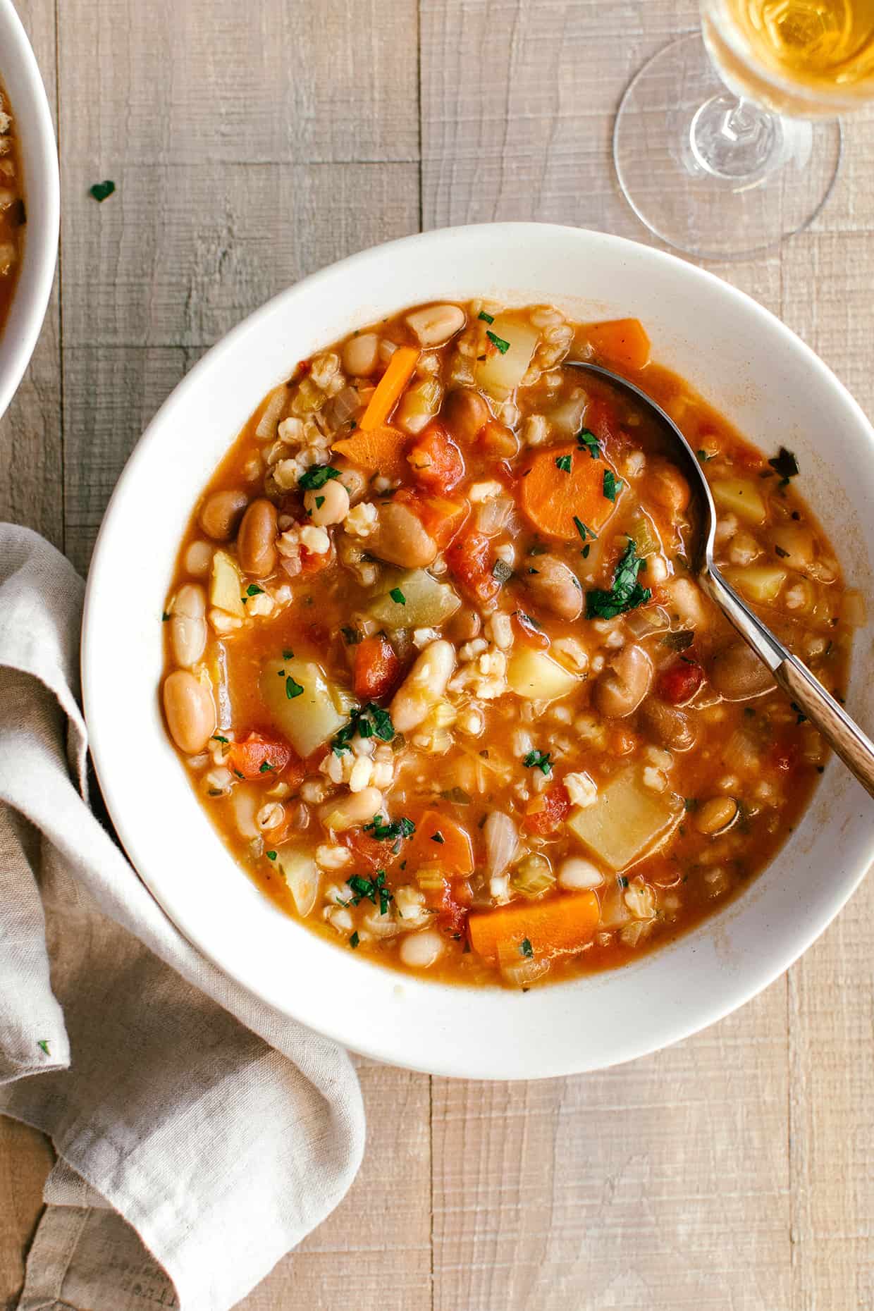 close view of thick barley soup with carrots, potatoes and tomatoes