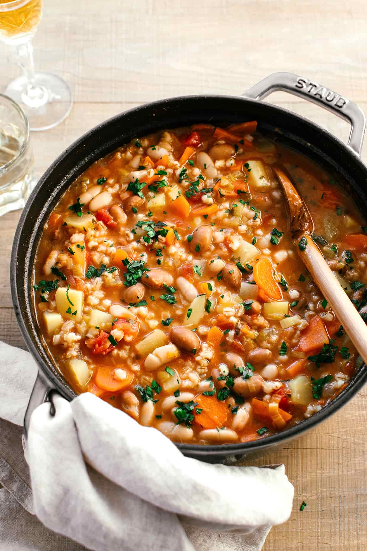 hearty vegetable barley soup cooked with a wooden soup in a large dutch oven