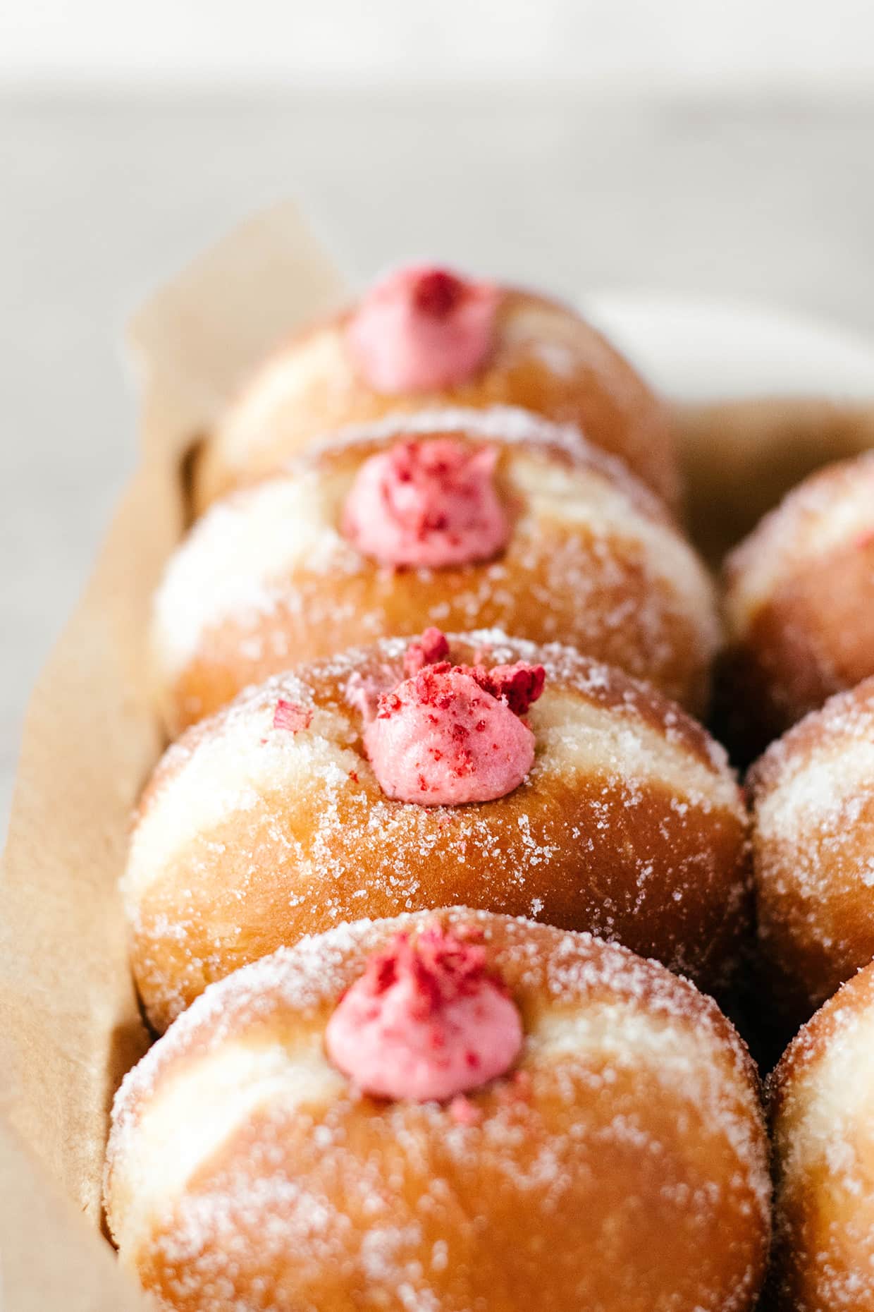 a row of raspberry cheesecake brioche doughnuts 