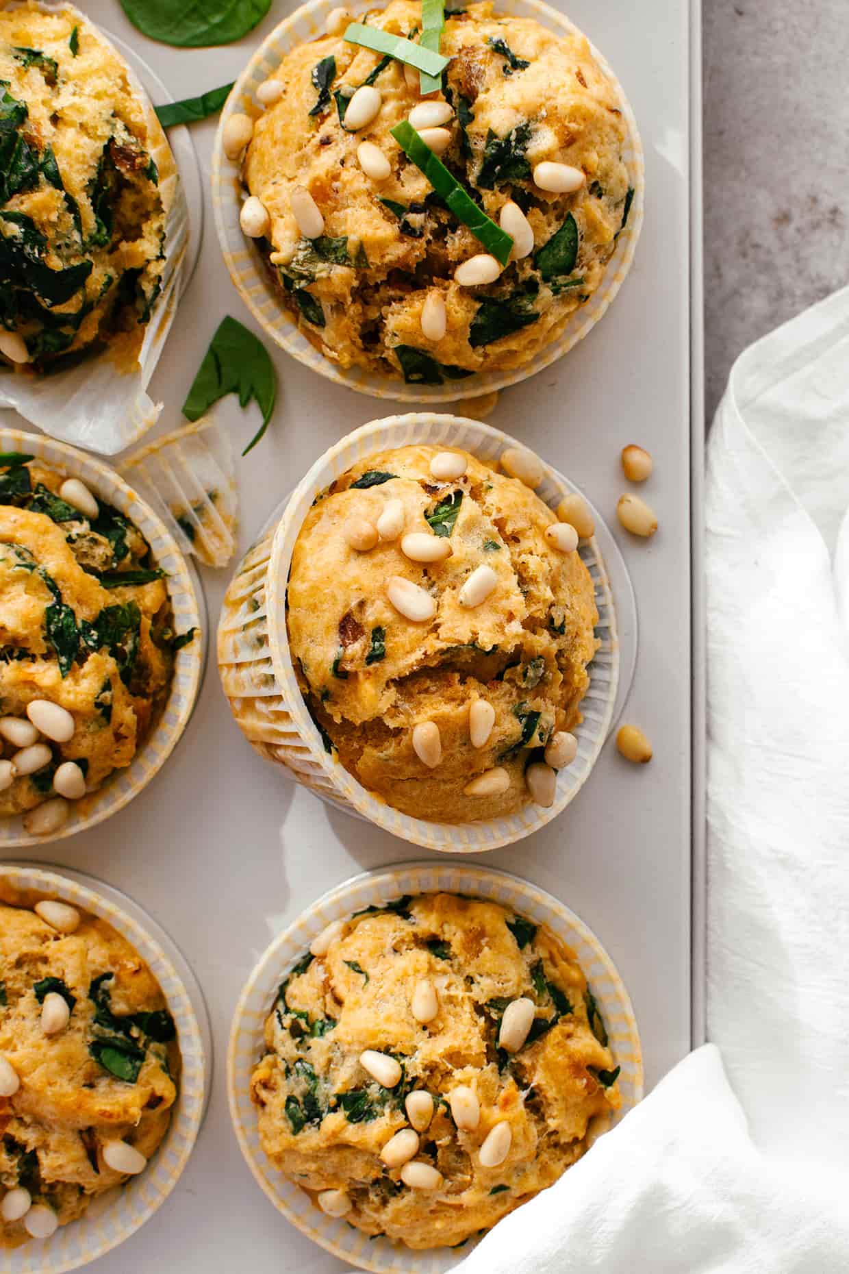 close view of spinach cheddar muffins with pine nuts on top