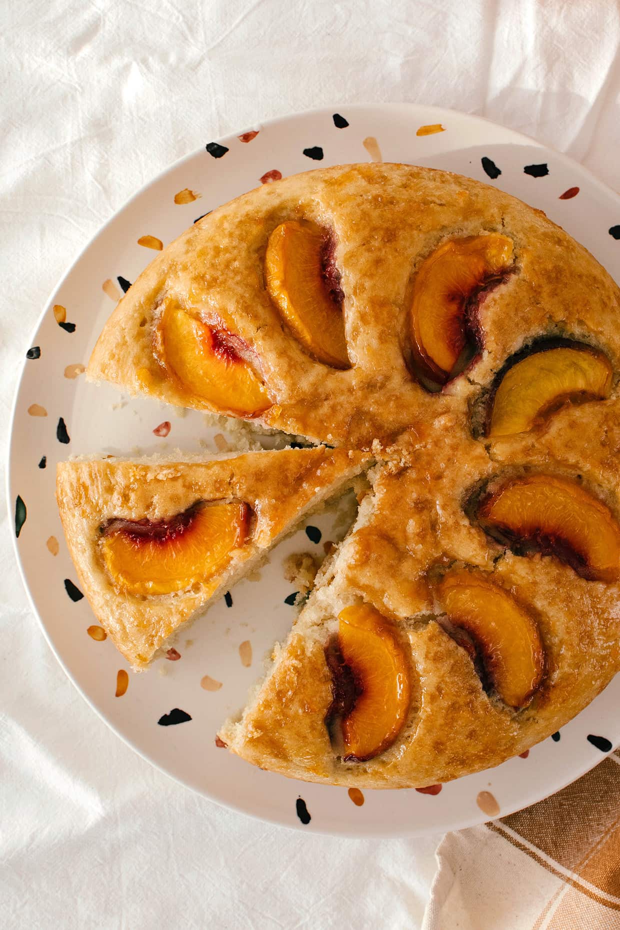 sliced peach cake on a plate