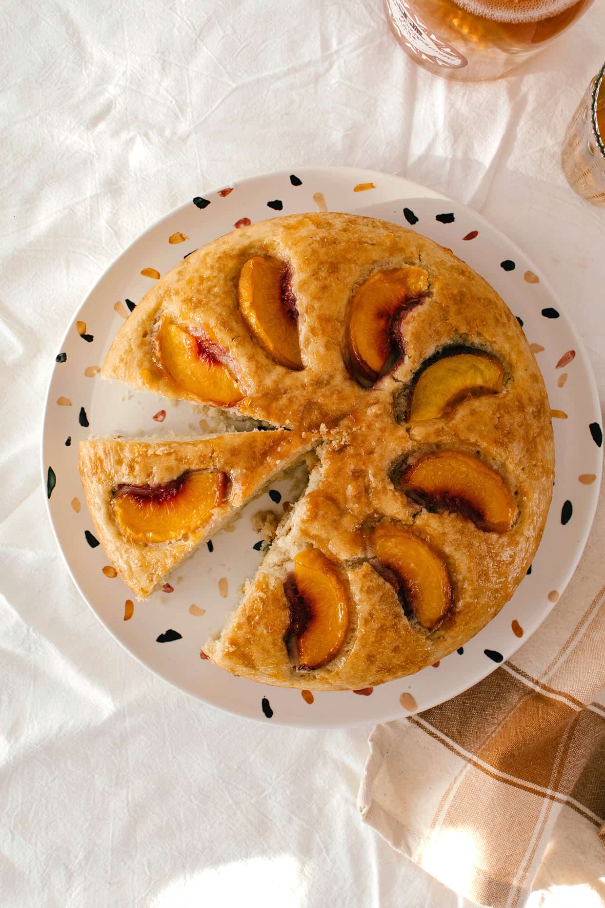 vegan peach snacking cake shot from above, sliced on a plate