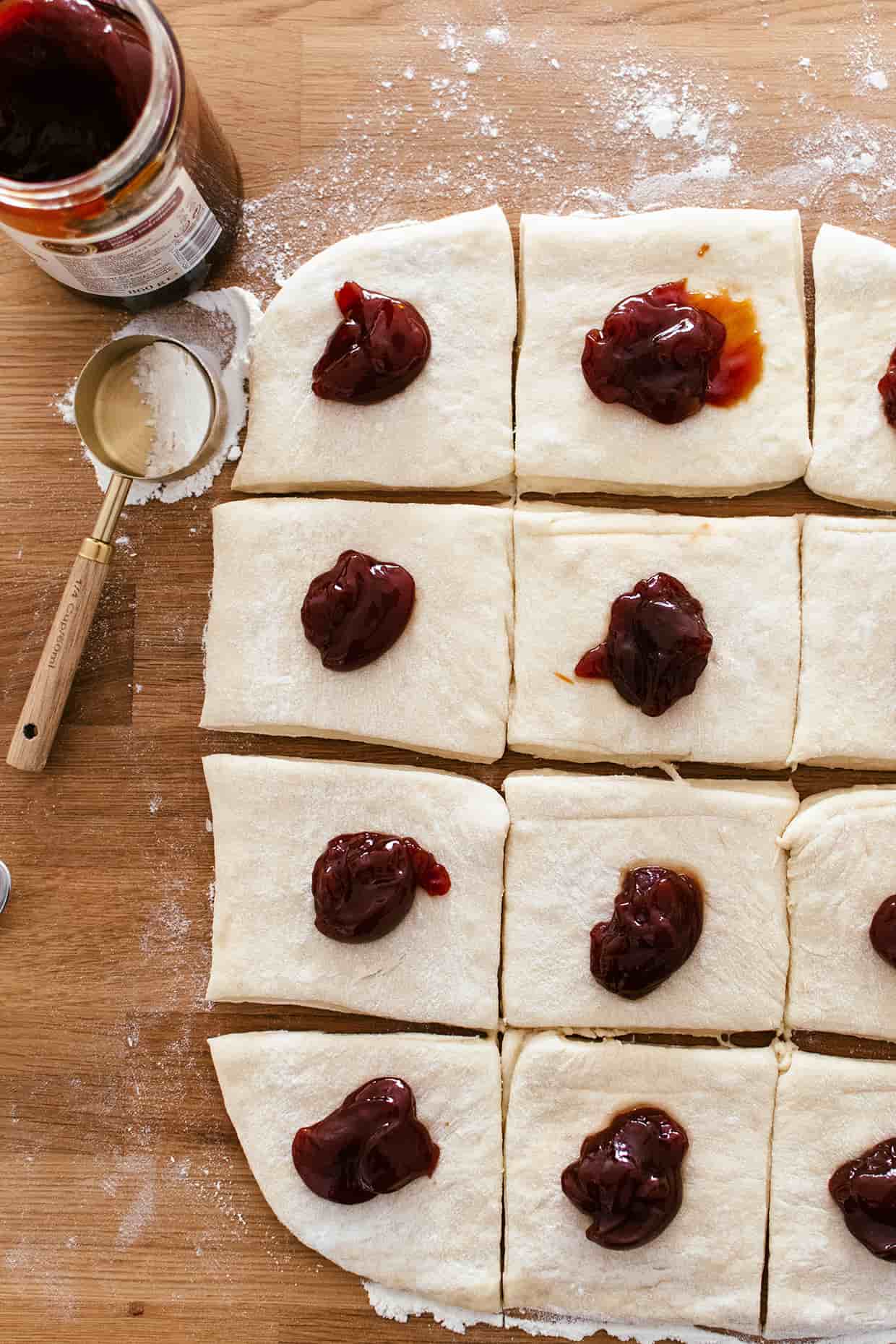 rolled out yeasted dough, sliced into squares, each topped with a tablespoon of jam in the center