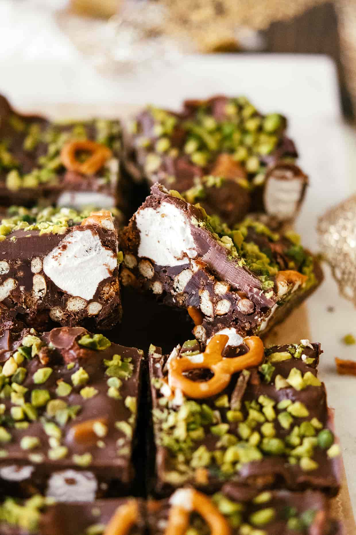 close view of a slice of no-bake chocolate bars, with marshmallows and pistachios