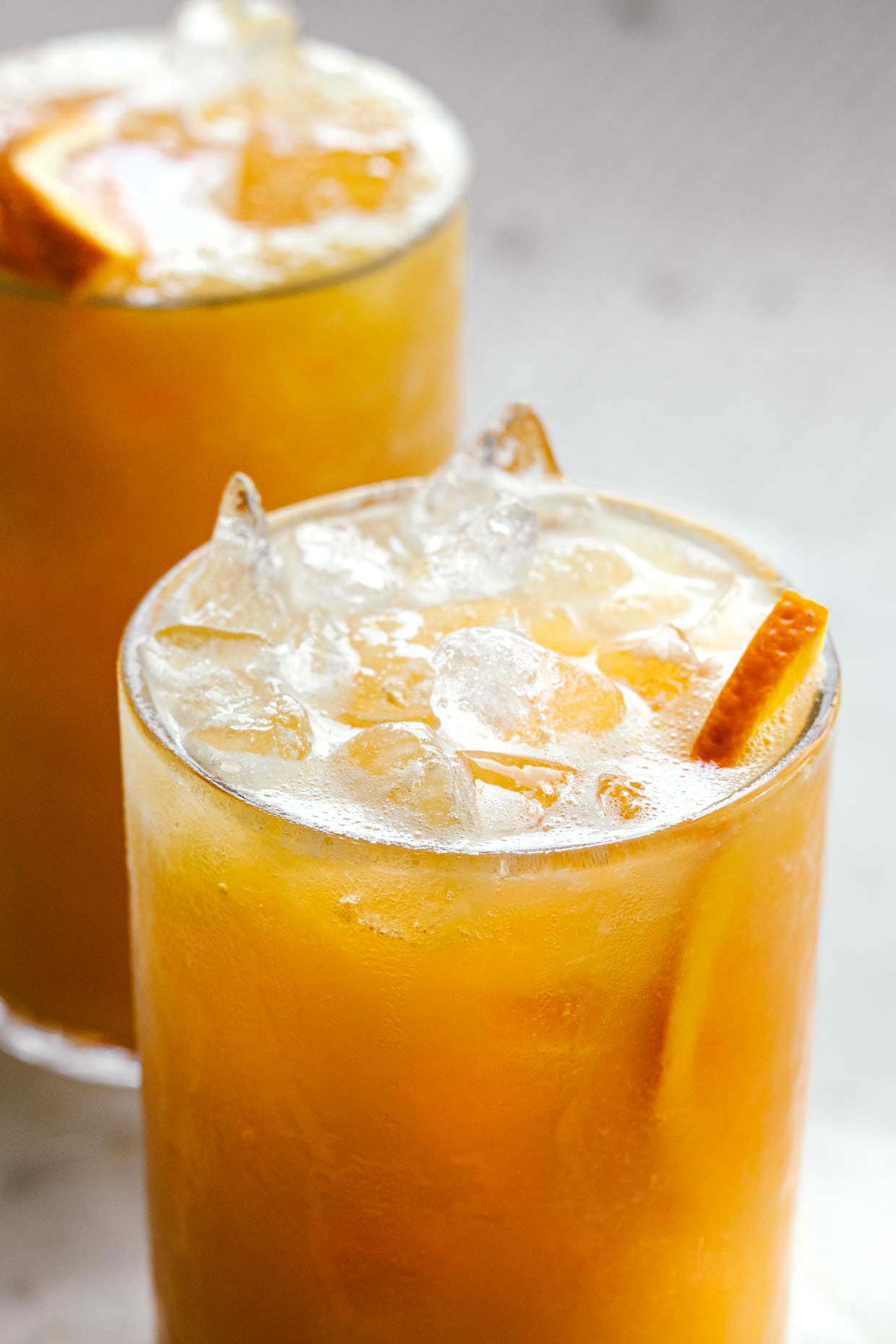 close view of orange juice served in glass over ice