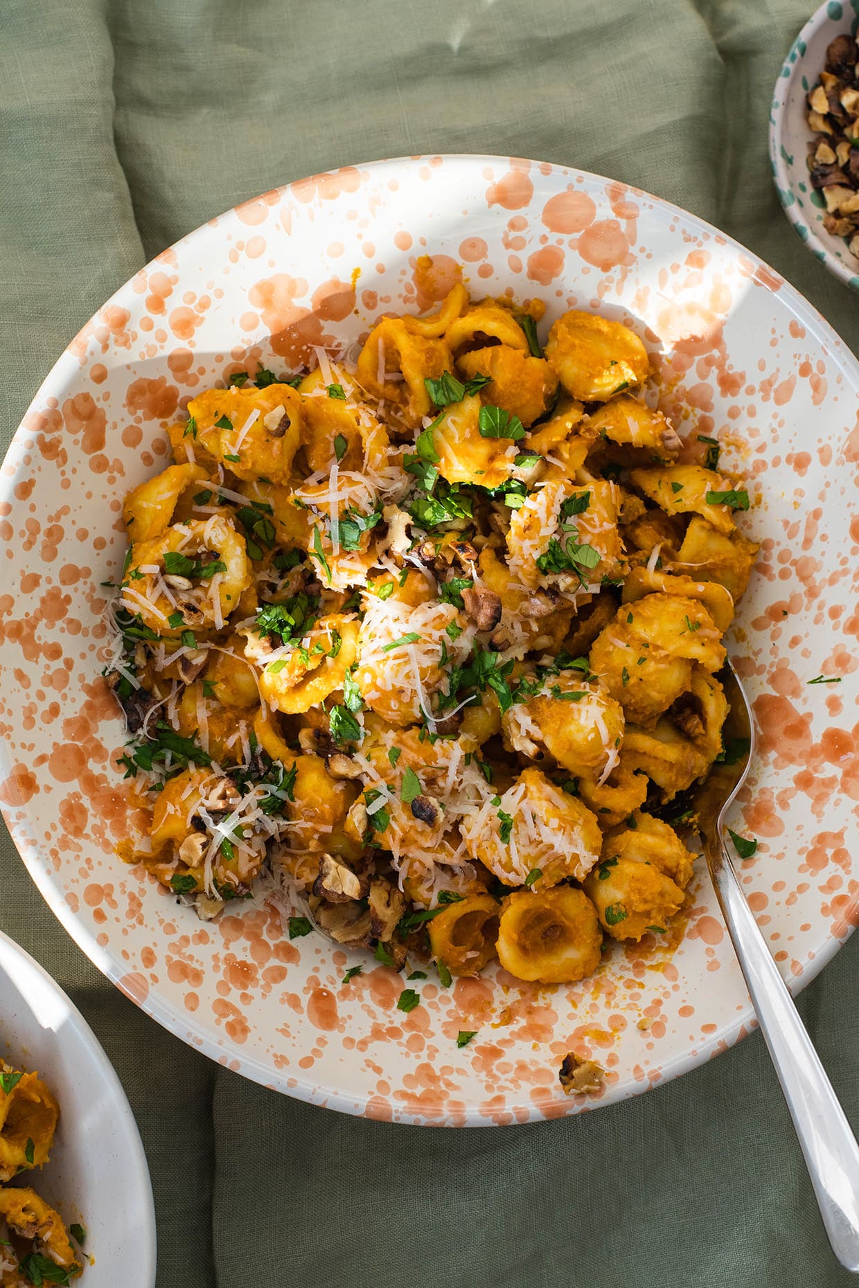 Quick pumpkin orecchiette with walnuts, grated parmesan and parsley, served in a deep plate