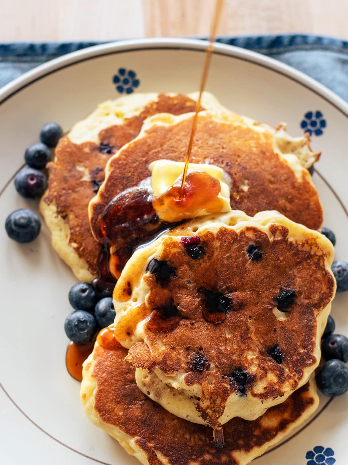 maple syrup poured over butter and pancakes