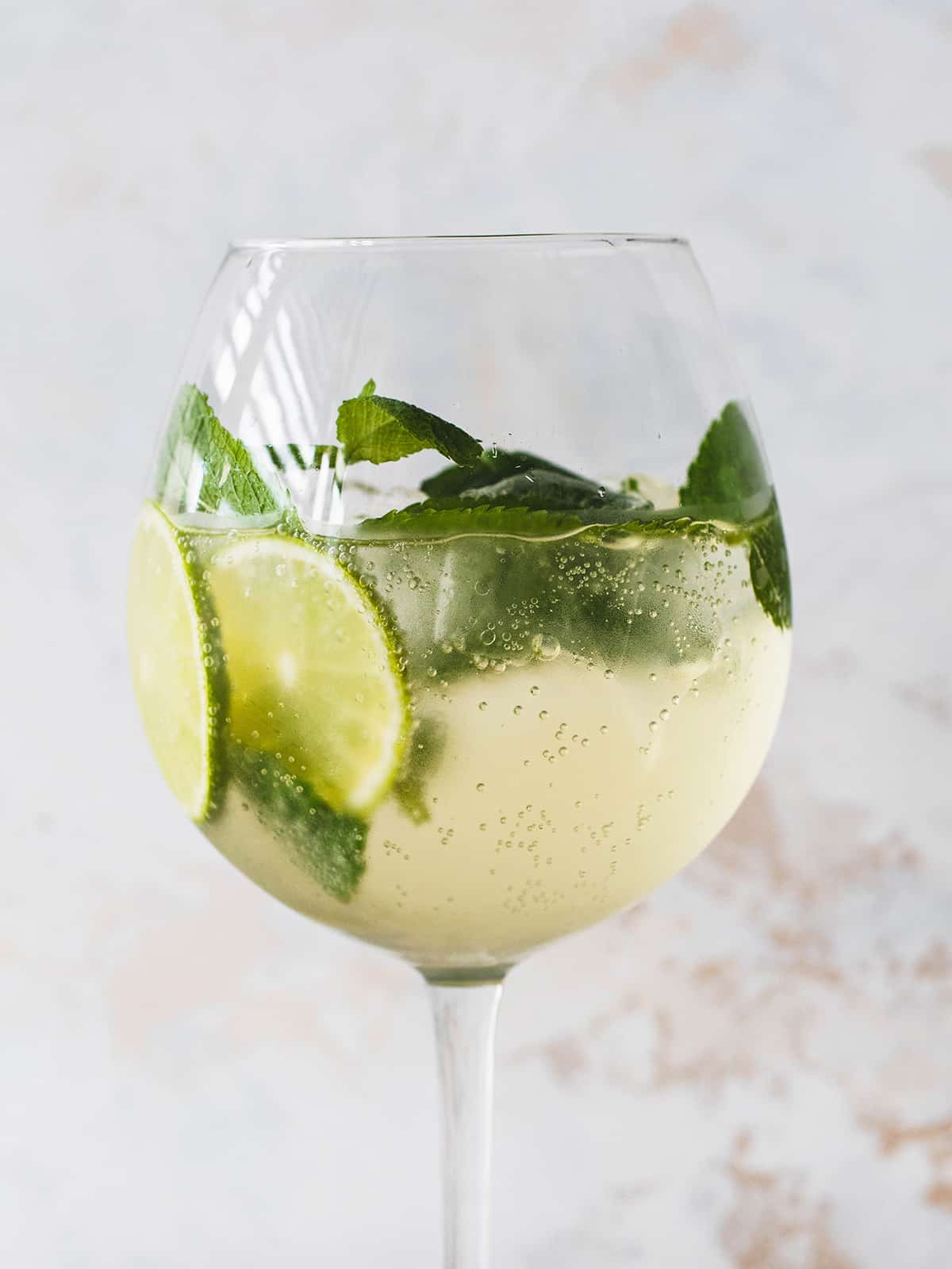 sparkling wine with mint and limes in glass