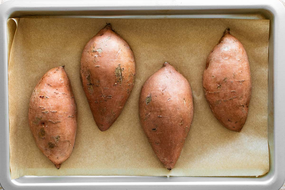 sliced sweet potatoes on a baking sheet
