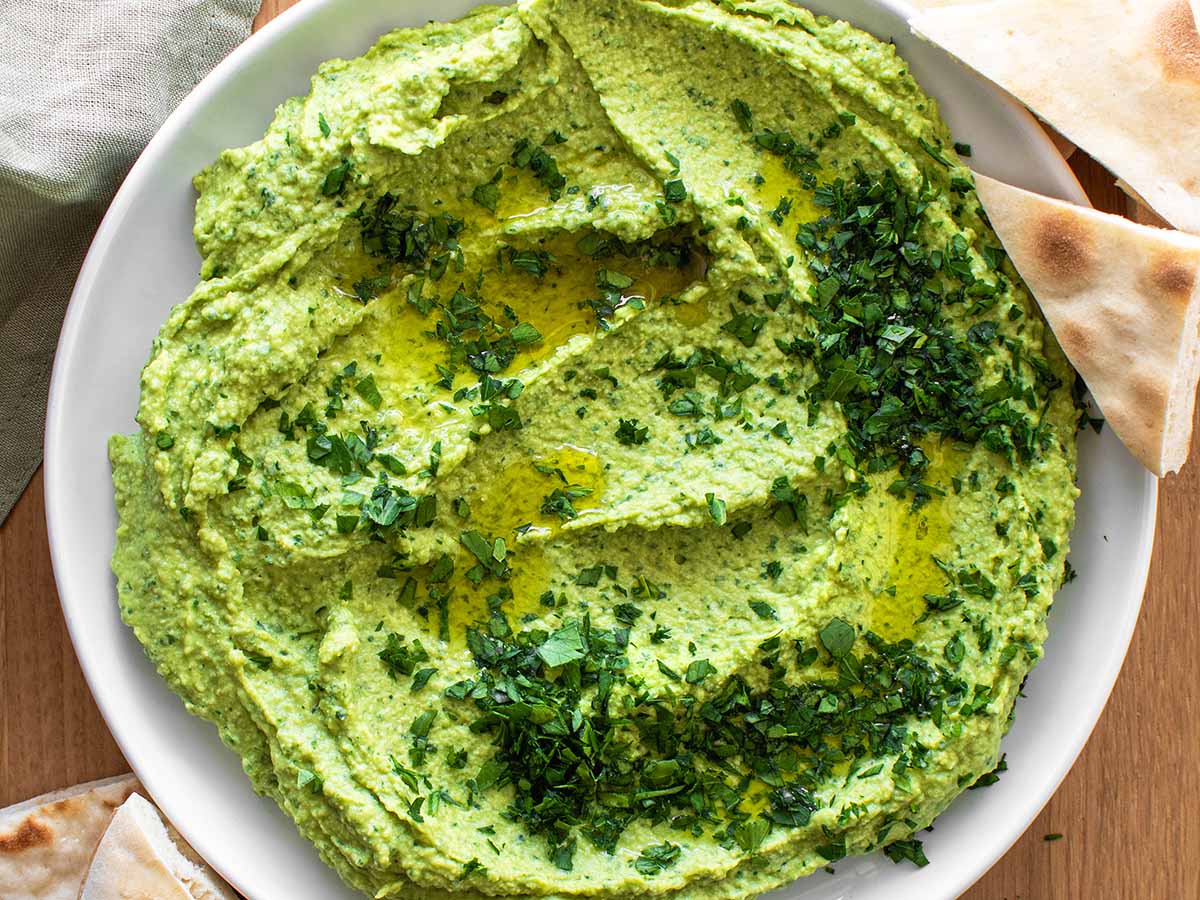 green hummus with parsley and pita bread