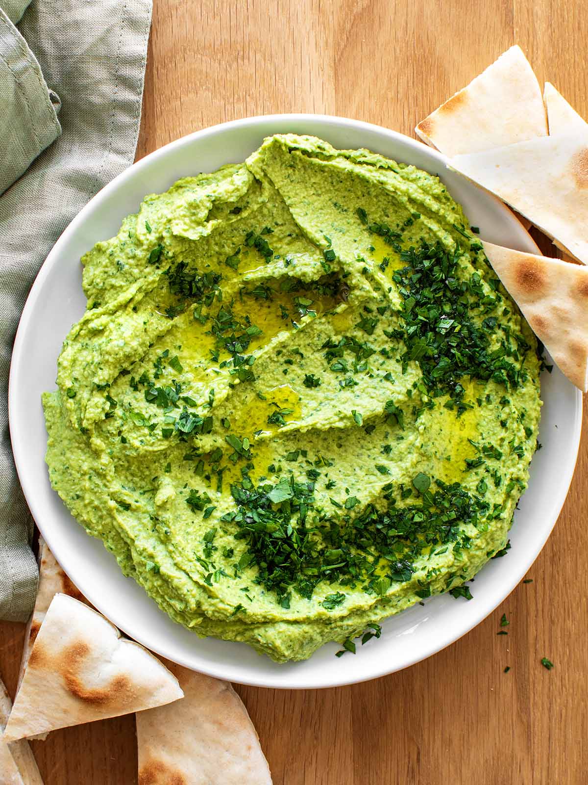 green hummus with parsley and pita bread